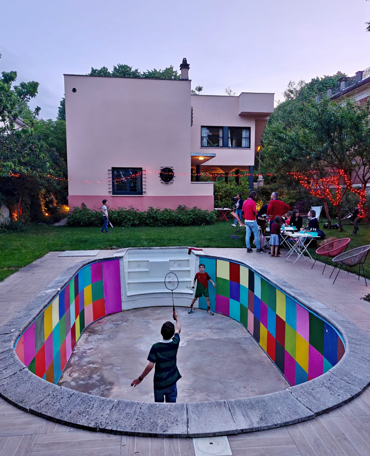 Badminton dans la piscine peinte le soir, guirlandes lumineuses, Villa Trapenard